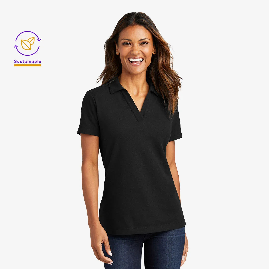 Woman wearing Port Authority Women's C-FREE Cotton Blend Pique Polo Shirt in Black - LK867