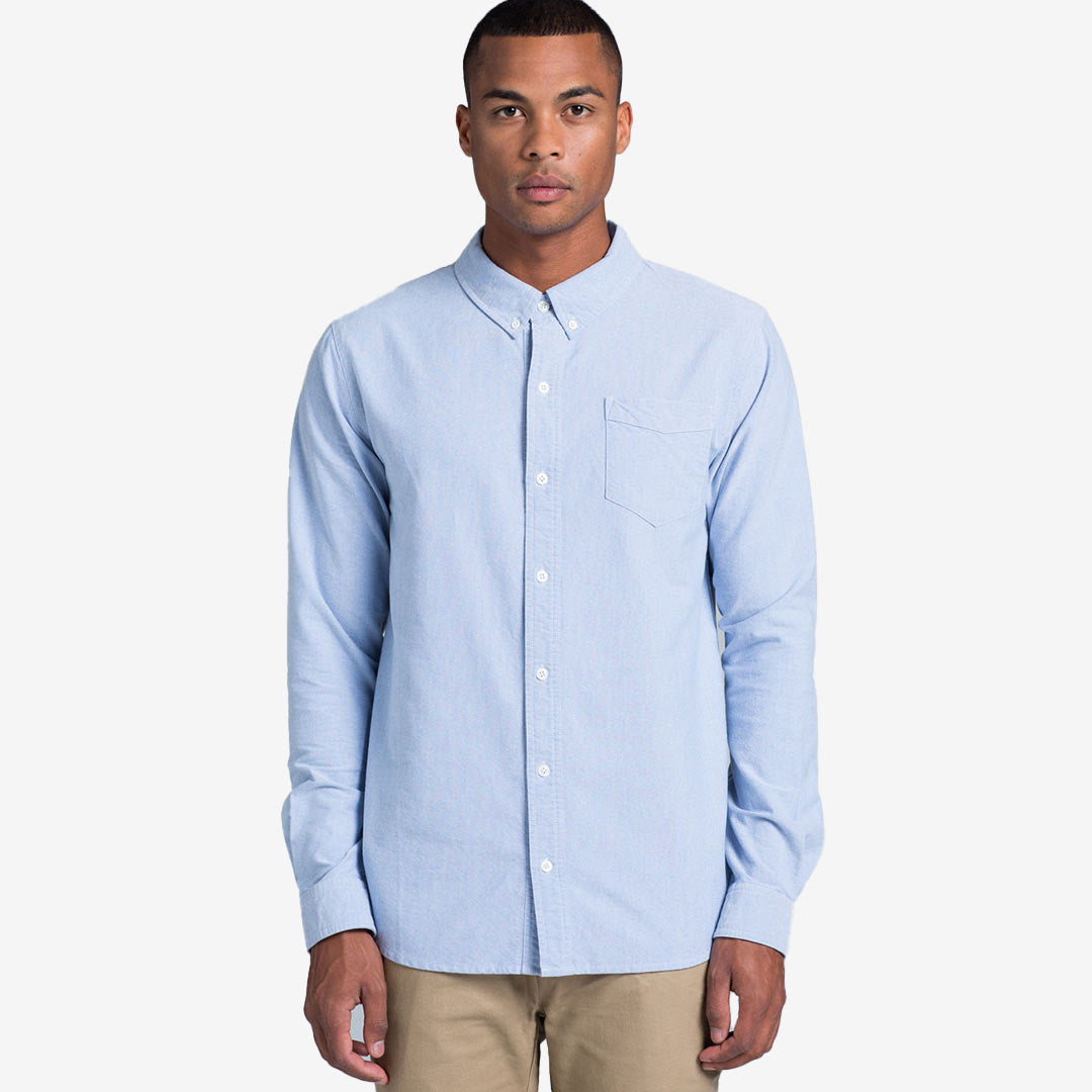 Man wearing AS Colour Men's Oxford Casual Long Sleeve Shirt in Light Blue Front - 5401