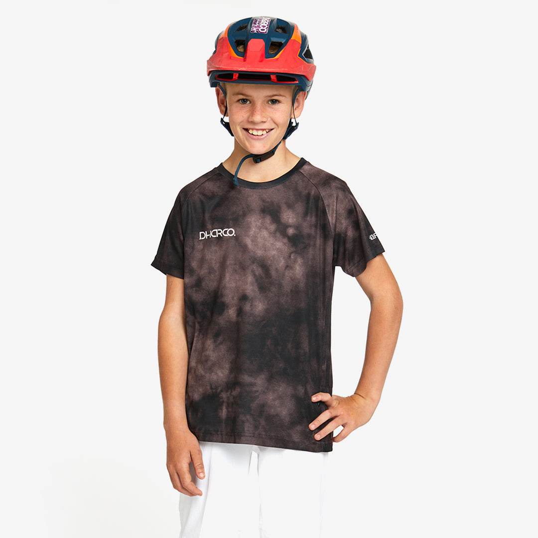 A kid wearing DHaRCO Custom Branded Youth Short Sleeve Jersey in Driftwood -YSS
